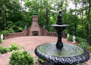 Outdoor fireplace and fountain in landscaped home